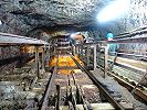 Standseilbahn Bergwerk Gonzen Gesenk Fluhwand - Strecke der ehemaligen Standseilbahn im Bergwerk - Entladestelle, oben Kalksilo beleuchtet, darunter Erzsilo. Seitliche Auflaufschienen zur Oeffnung der Frontklappe der Fördertonne